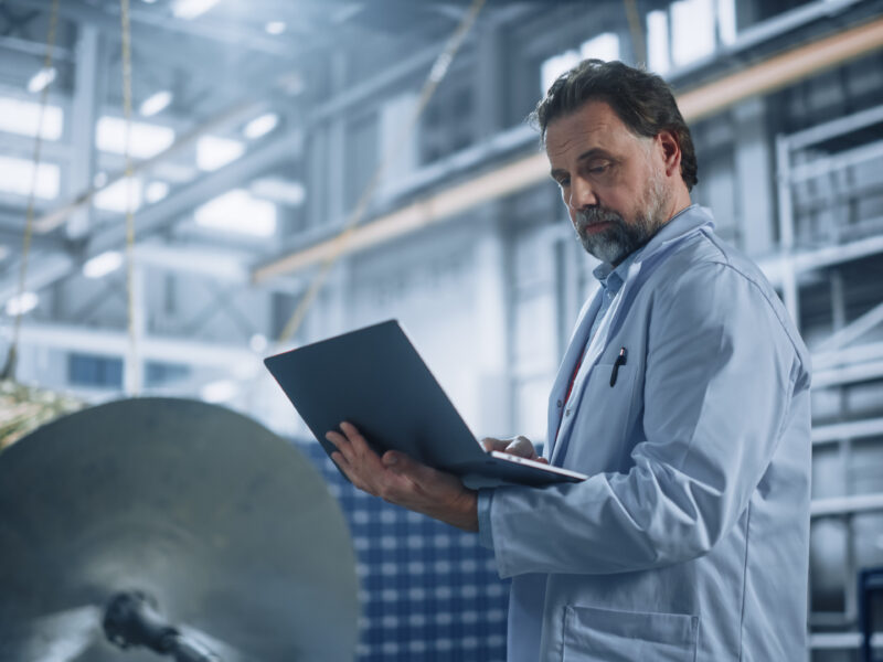 Male,Engineer,Uses,Laptop,Computer,While,Working,On,Satellite,Construction.